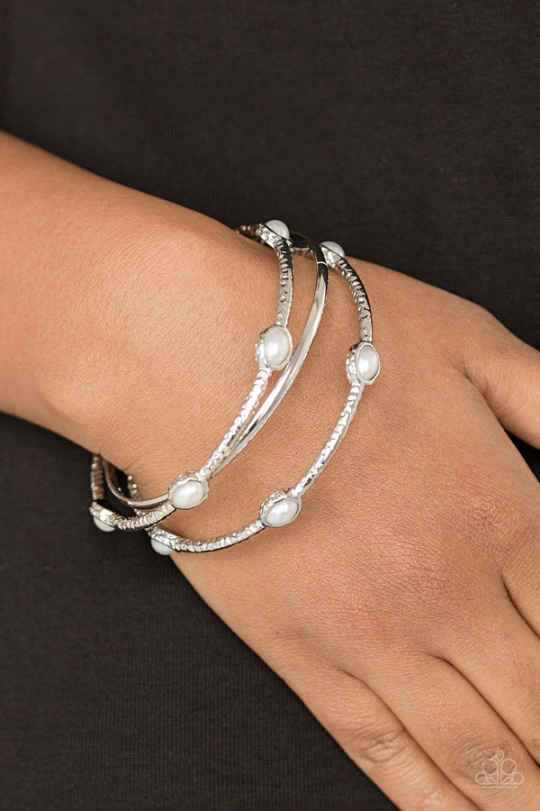 Bangle Belle - Pearl Paparazzi Bracelet-Jazzi Jewelz Boutique
Delicately hammered in shimmer, a pair of pearly white encrusted bangles joins a smooth silver bangle around the wrist for a refined fashion.
Sold as one set of three bracelets.
Paparazzi Accessories are  100% lead free and nickel free. 
