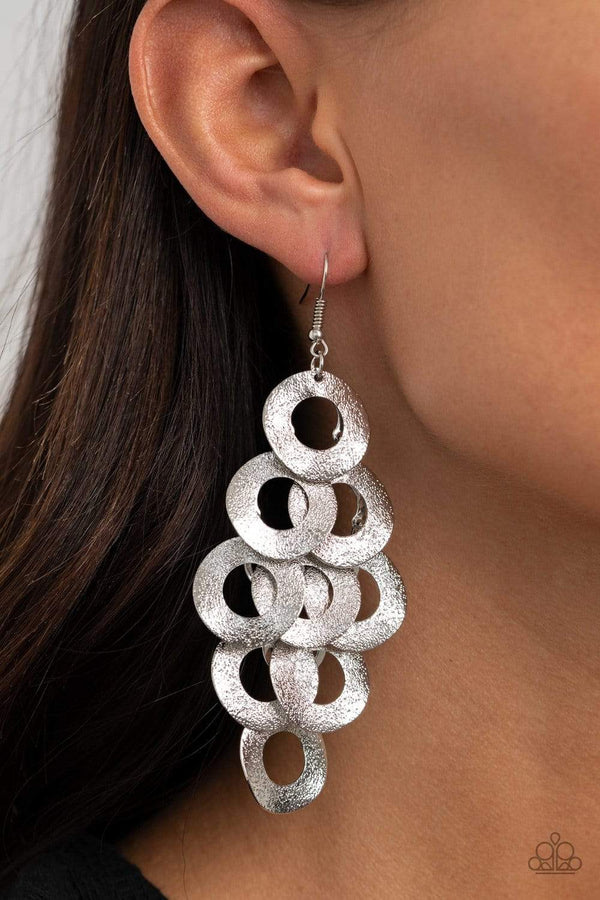 Scattered Shimmer-Silver Paparazzi Earrings-Jazzi Jewelz Boutique by Raven  .Delicately hammered in light-catching shimmer, rows of curved silver hoops delicately overlap into a noise-making lure. Earring attaches to a standard fishhook fitting.  Sold as one pair of earrings.  All Paparazzi Accessories are lead free and nickel free. 