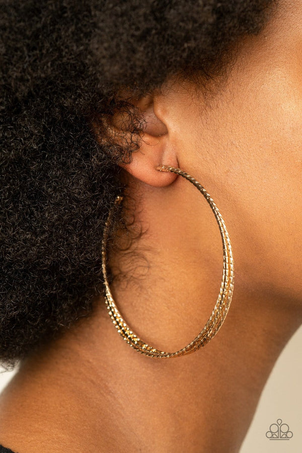 ﻿Watch and Learn-Gold Paparazzi Hoop Earrings-Jazzi Jewelz Boutique by Raven   Varying in hammered and diamond-cut textures, three glistening gold bars dramatically curl into an oversized hoop for a glamorous finish. Earring attaches to a standard post fitting. Hoop measures approximately 3 1/4