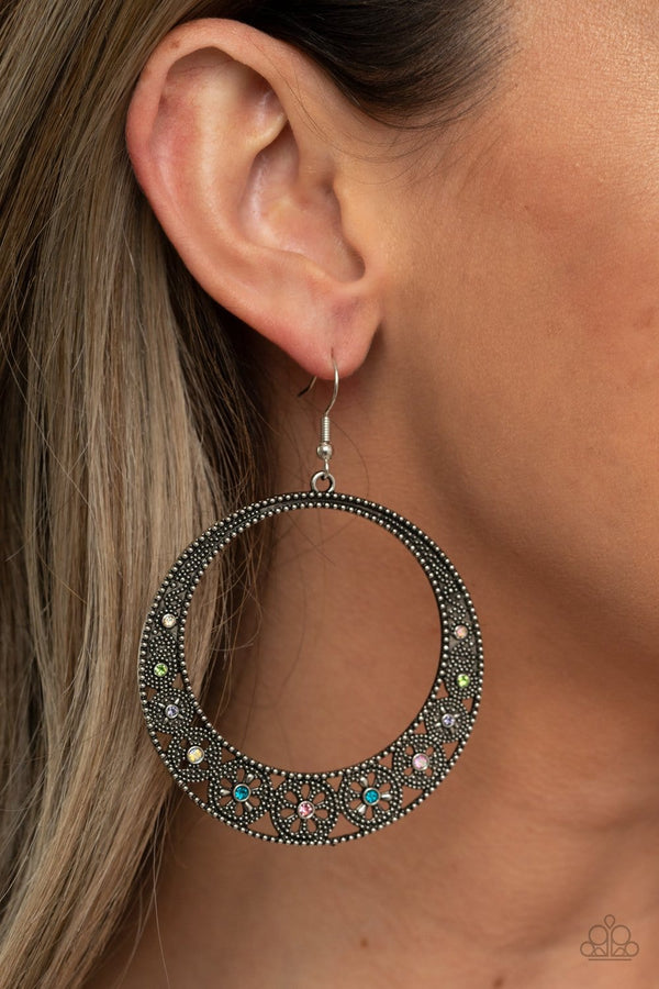 ﻿Bodaciously Blooming-Multicolored Rhinestone Paparazzi Earrings  Dotted with dainty multicolored rhinestones, studded wheel-like frames connect into a studded hoop for a whimsical look. Earring attaches to a standard fishhook fitting.  Sold as one pair of earrings.