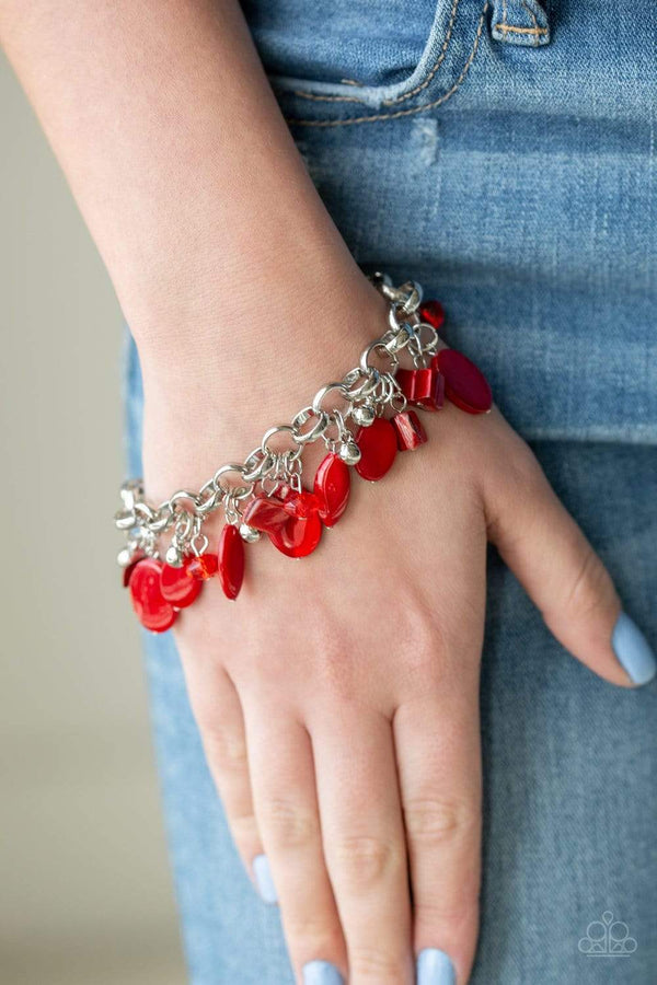 Shop Our Seashore Sailing Red Bracelet  A red bracelet with a collection of red shell-like beads, red crystal-like beads, and shiny silver beads swing from a silver chain