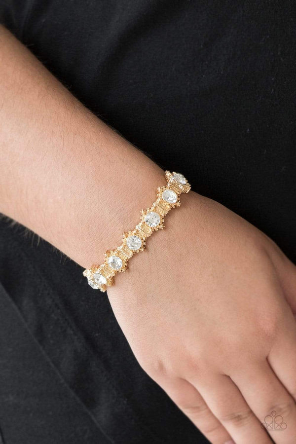 Strut Your Stuff-Gold Bracelet-Jazzi Jewelz Boutique by Raven   Featuring glittery white rhinestone centers, ornate golden frames are threaded along stretchy bands, linking across the wrist for a refined look. Sold as one individual bracelet.  All Paparazzi Jewelry is lead free and nickel free. 